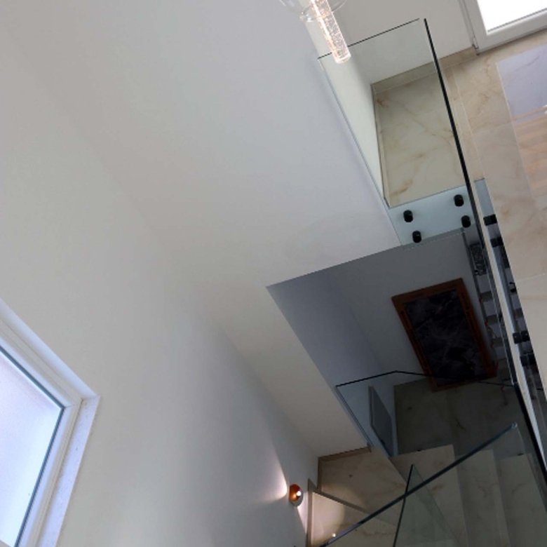 Elegant staircase with glass railings, marble steps, and designer lighting in Adana Villa&mdash;prime Ulcinj investment at immorenta.me.