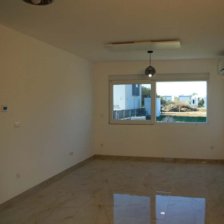 Bright Adana Villa room in Ulcinj, Montenegro with cream walls, glossy tile, AC, and large window. Invest via immorenta.me by ekosphere doo.