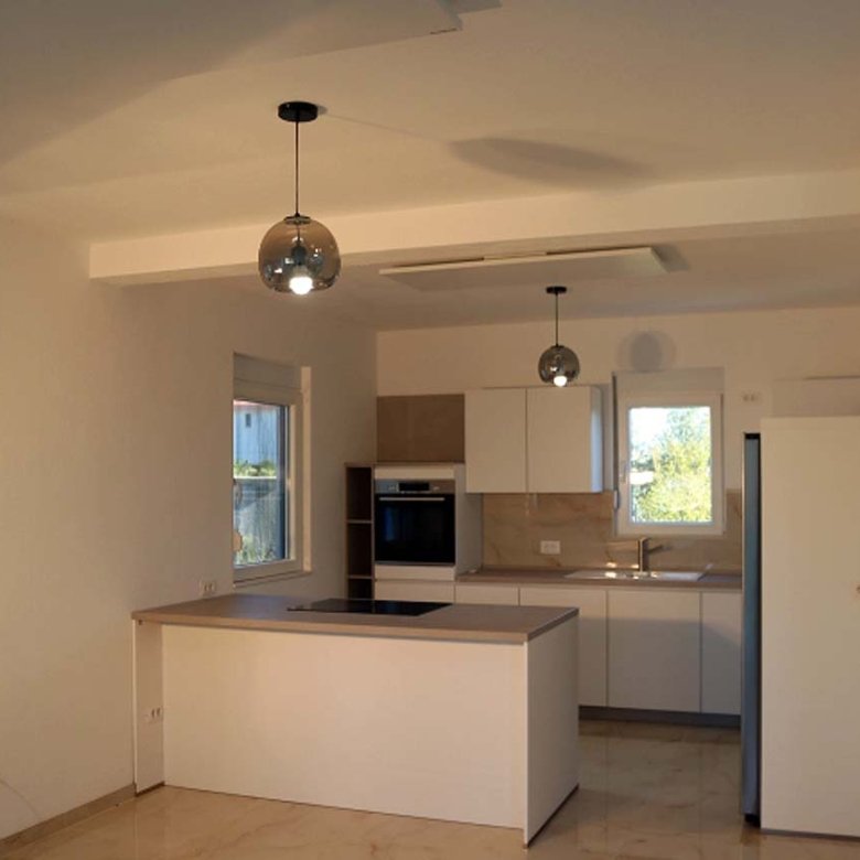 Sleek modern kitchen in Ulcinj villa: white cabinets, island, premium appliances&mdash;ideal Montenegro investment. By ekosphere doo.