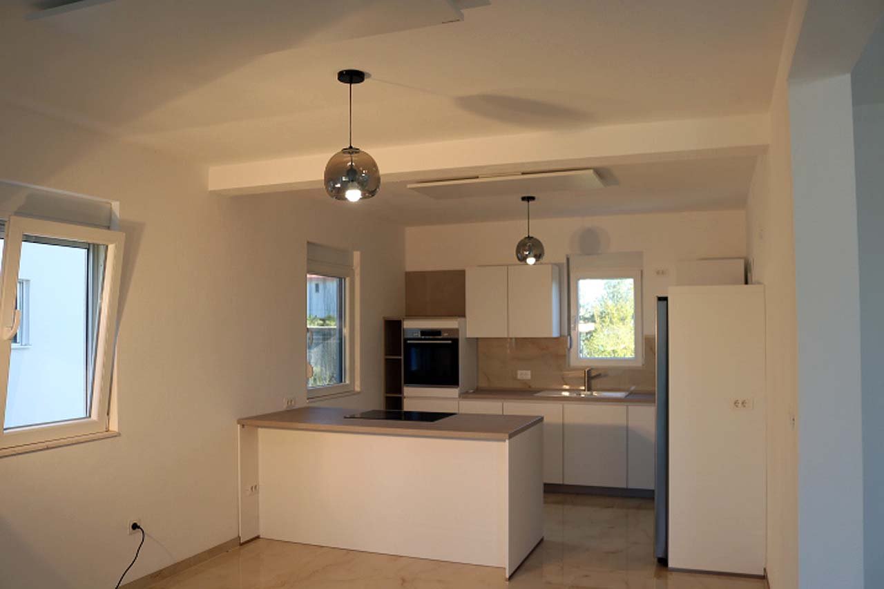 Sleek modern kitchen in Ulcinj villa: white cabinets, island, premium appliances&mdash;ideal Montenegro investment. By ekosphere doo.