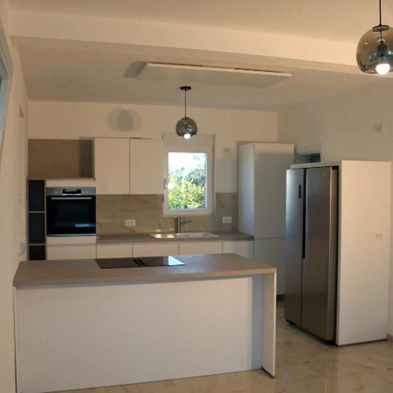 Luxurious Adana Villa kitchen in Ulcinj: white cabinets, island cooktop, marble floors&mdash;ideal real estate at immorenta.me.