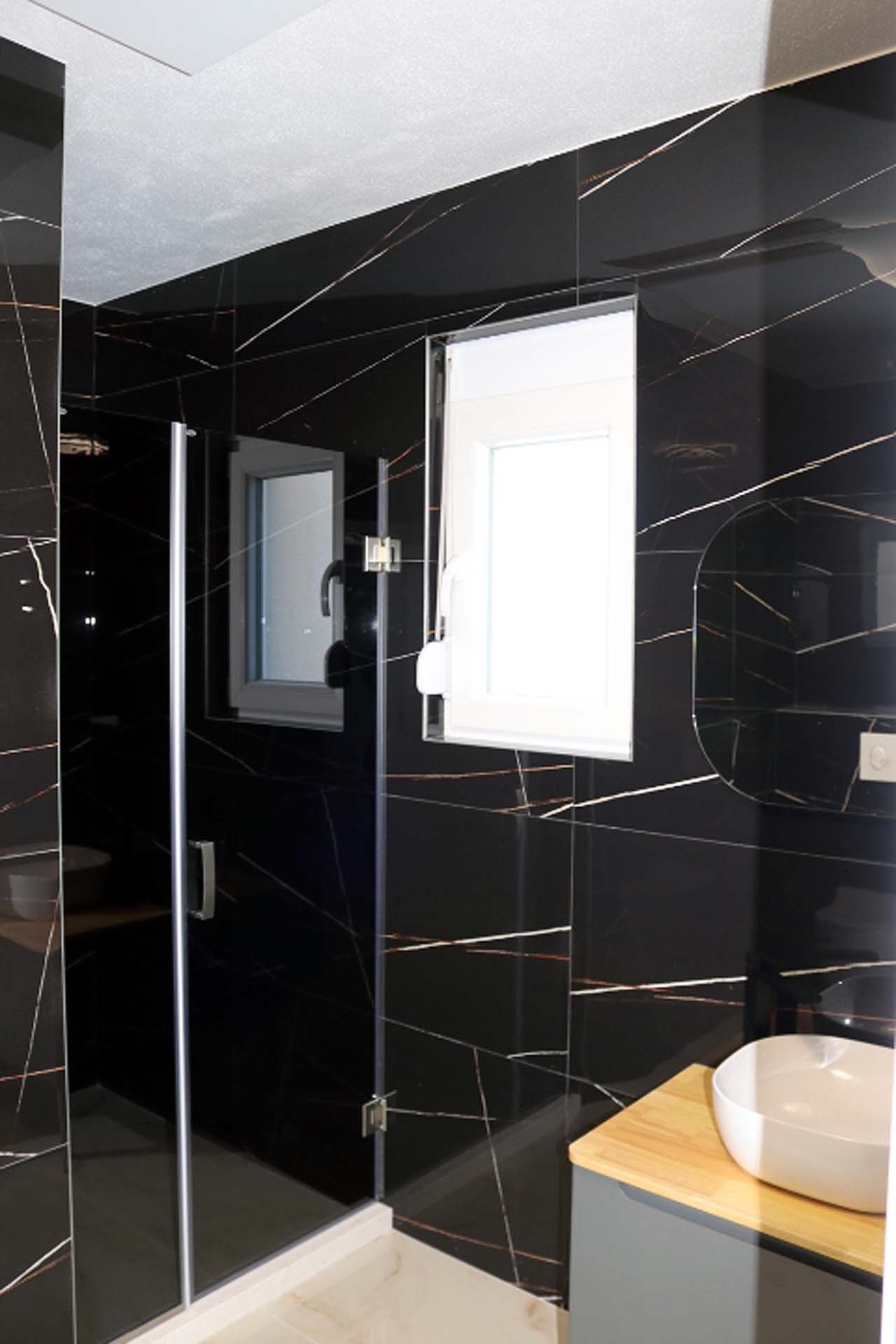Luxury bathroom in Adana Villa, Ulcinj: elegant black-gold tiles, glass shower, designer sink; investment via immorenta.me (ekosphere doo).
