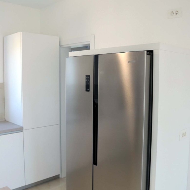 Sleek stainless steel fridge and minimalist kitchen in Adana Villa, Ulcinj&mdash;prime investment on immorenta.me by ekosphere doo.