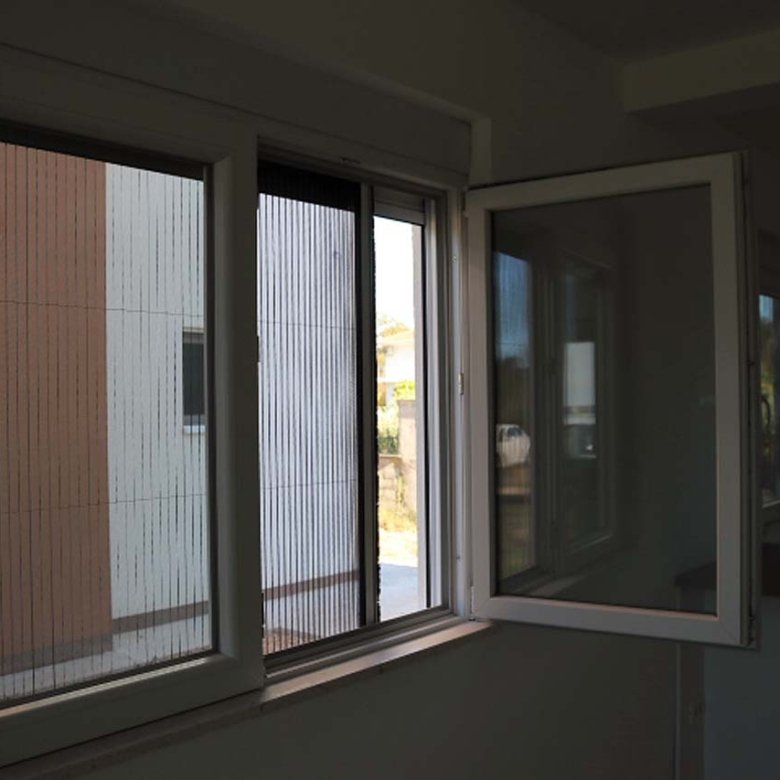 Bright white-framed window in Adana Villa, Ulcinj. Lush greenery views, investment potential. On immorenta.me by ekosphere doo.