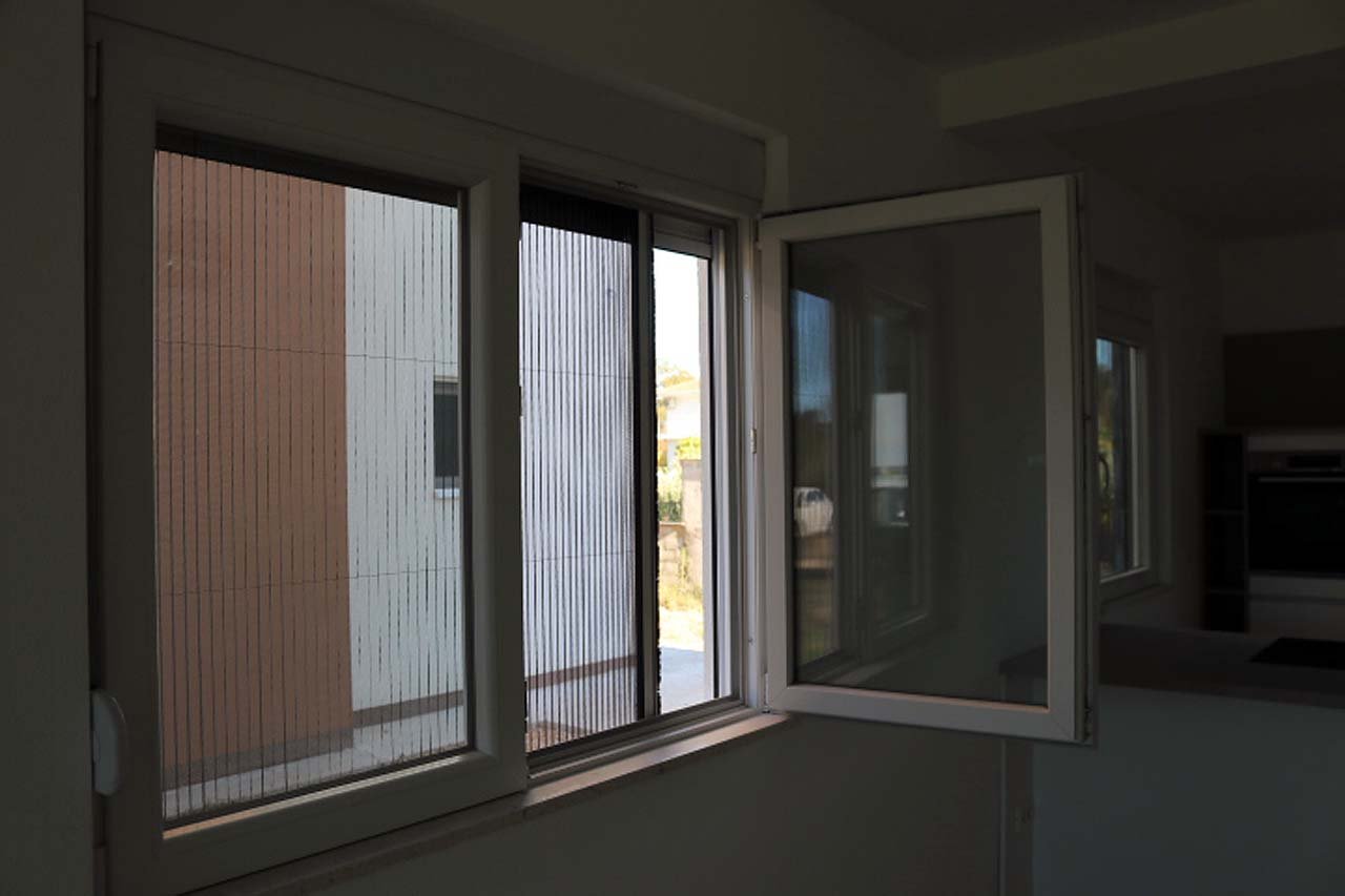 Bright white-framed window in Adana Villa, Ulcinj. Lush greenery views, investment potential. On immorenta.me by ekosphere doo.