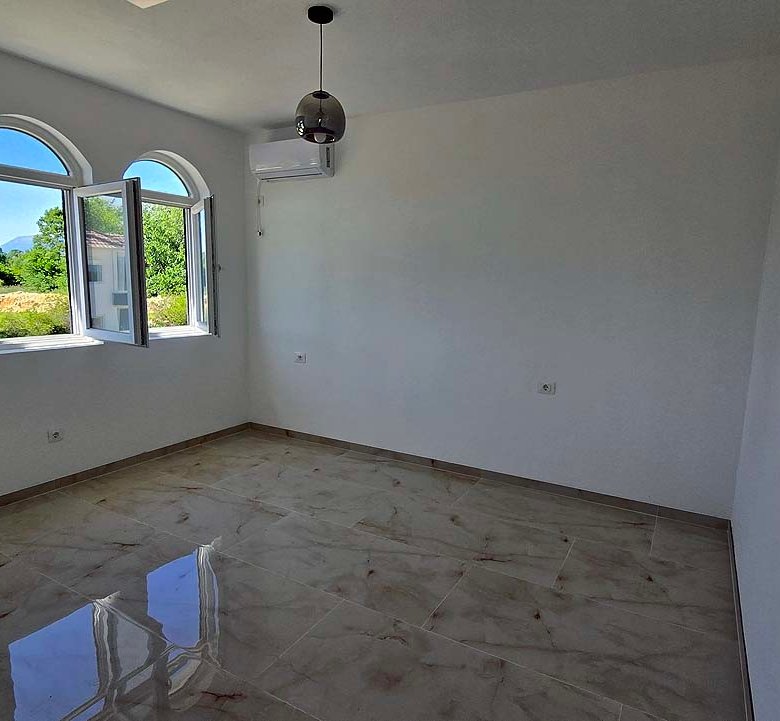 Bright, unfurnished Ulcinj room for sale with arched windows, tiled floor, AC. Invest in Montenegro with immorenta.me by ekosphere doo.