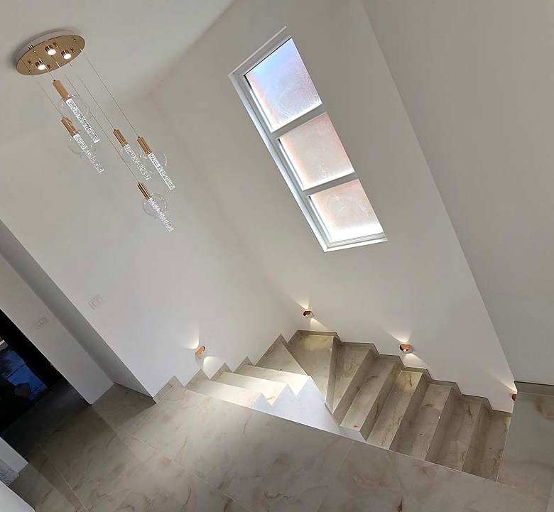 Elegant staircase with beige steps, chic lights, and tall window&mdash;ideal Ulcinj investment, listed by immorenta.me (ekosphere doo).