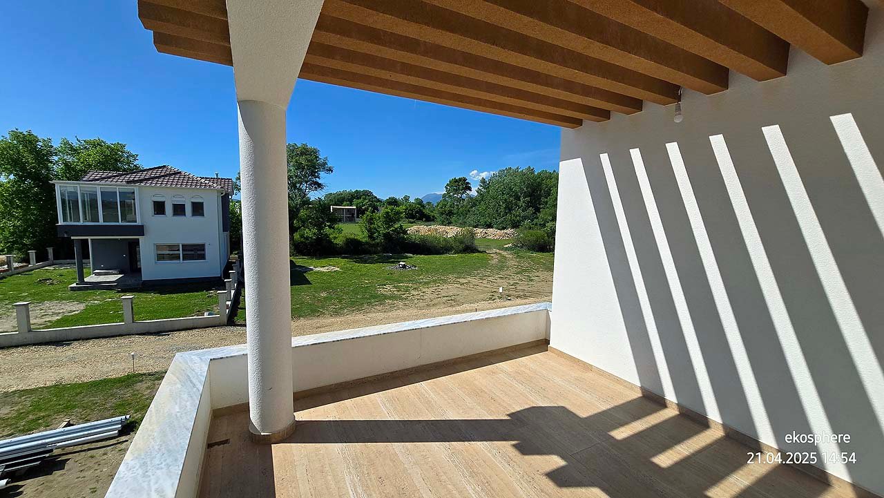 Bright covered balcony with wooden beams, lush yard, and modern home&mdash;prime Ulcinj real estate from immorenta.me/Ekosphere doo.