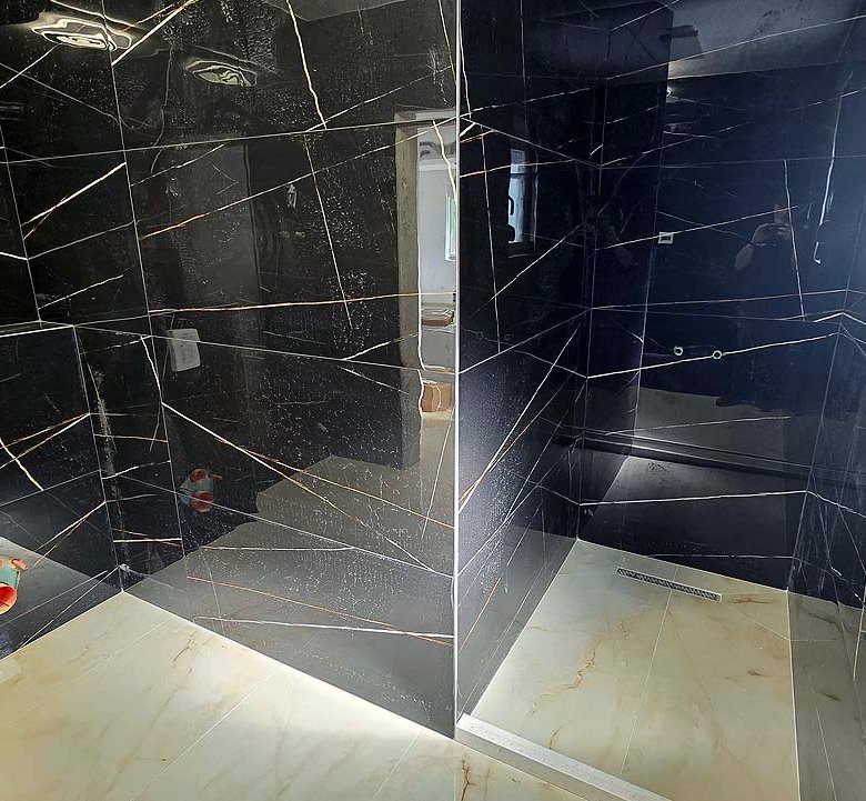 Luxury bathroom in Ulcinj: black marble walls, bright marble floors, walk-in shower, sunny window. Exclusive at immorenta.me by Ekosphere doo.