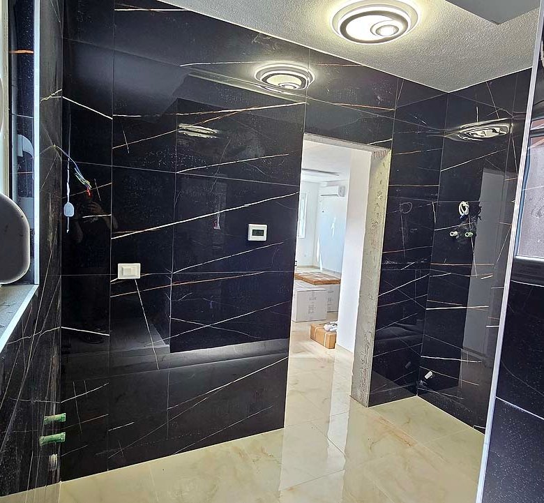 Contemporary room with black marble walls, window, and doorway to bright space. Prime Ulcinj real estate&mdash;immorenta.me by ekosphere doo.