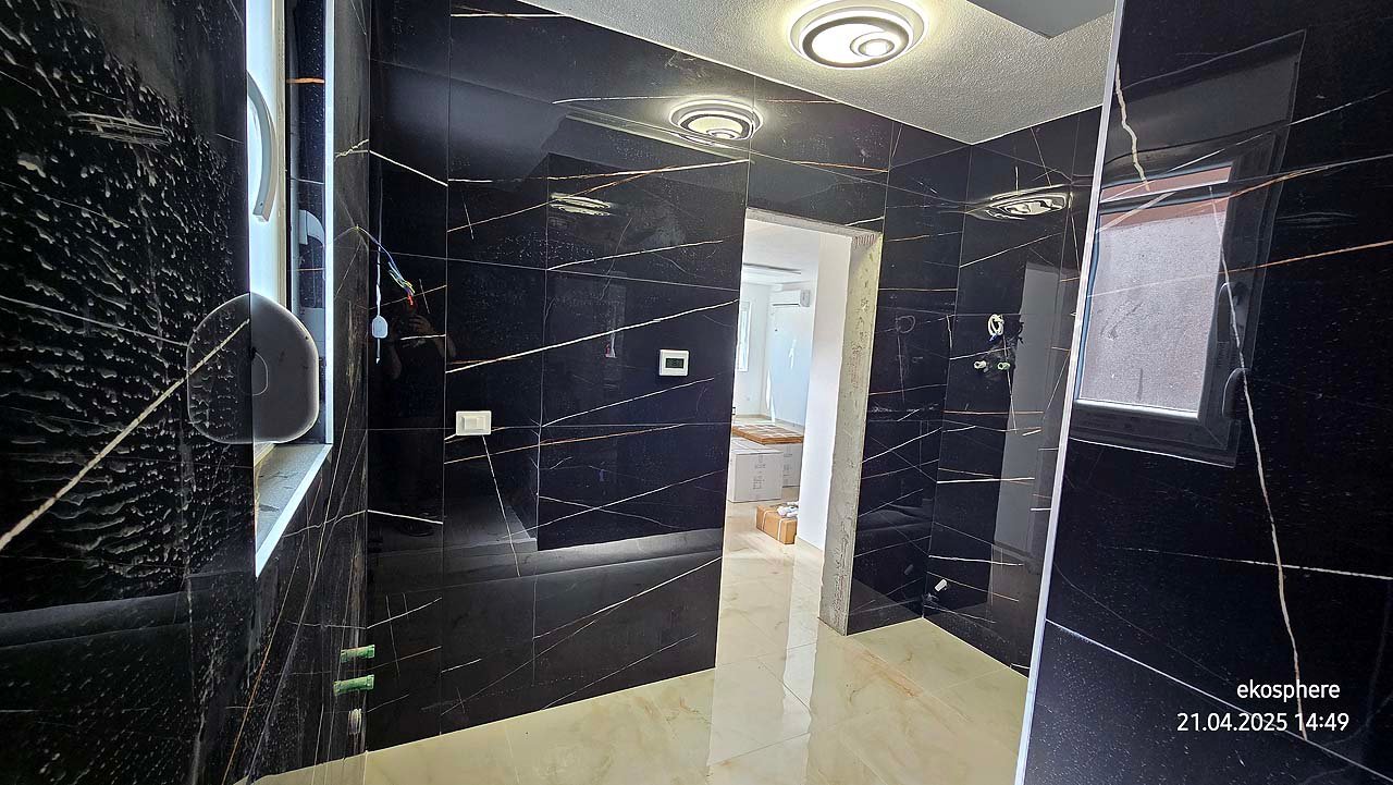 Contemporary room with black marble walls, window, and doorway to bright space. Prime Ulcinj real estate&mdash;immorenta.me by ekosphere doo.