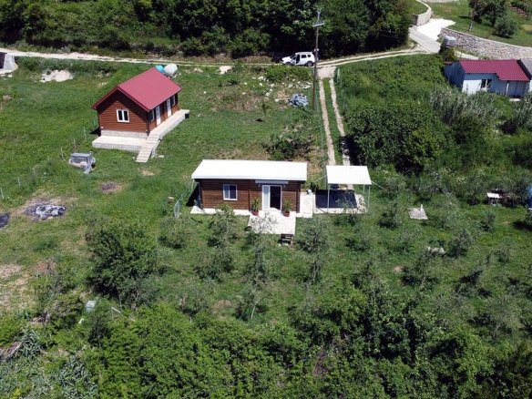 Aerial view of eco-friendly Ulcinj property: 2 wooden homes, outbuildings, lush land. Invest via immorenta.me by Ekosphere doo.