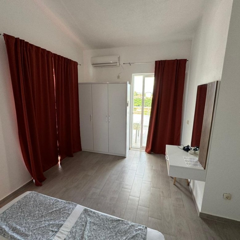 Elegant Ulcinj bedroom with red curtains, white wardrobe, desk, balcony&mdash;prime Montenegro real estate by ekosphere doo on immorenta.me.