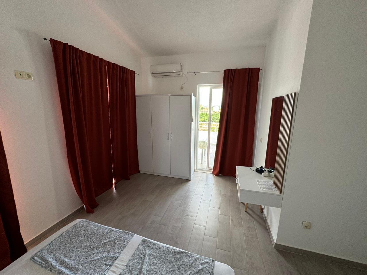 Elegant Ulcinj bedroom with red curtains, white wardrobe, desk, balcony&acirc;prime Montenegro real estate by ekosphere doo on immorenta.me.