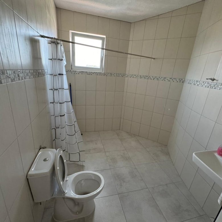 Modern bathroom in Ulcinj, Montenegro with beige tiles, shower, and natural light&mdash;ideal property listed on immorenta.me by ekosphere doo.