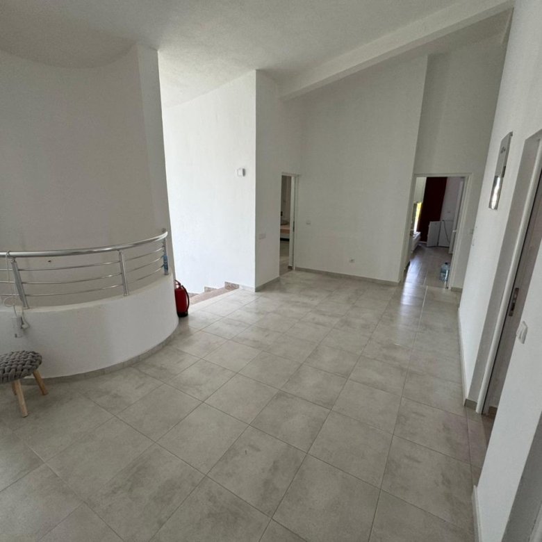 Bright, spacious room in Ulcinj with modern tiled floors, white walls, and staircase&mdash;investment potential via immorenta.me by ekosphere doo.