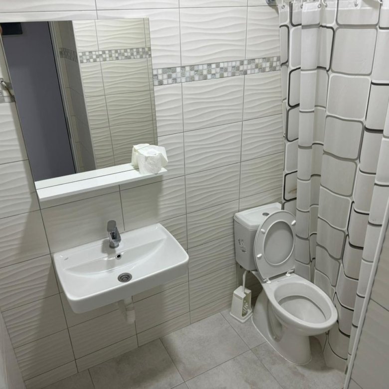 Modern white-tiled bathroom in Ulcinj, Montenegro; sleek fixtures&mdash;an ideal real estate investment on immorenta.me by ekosphere doo.