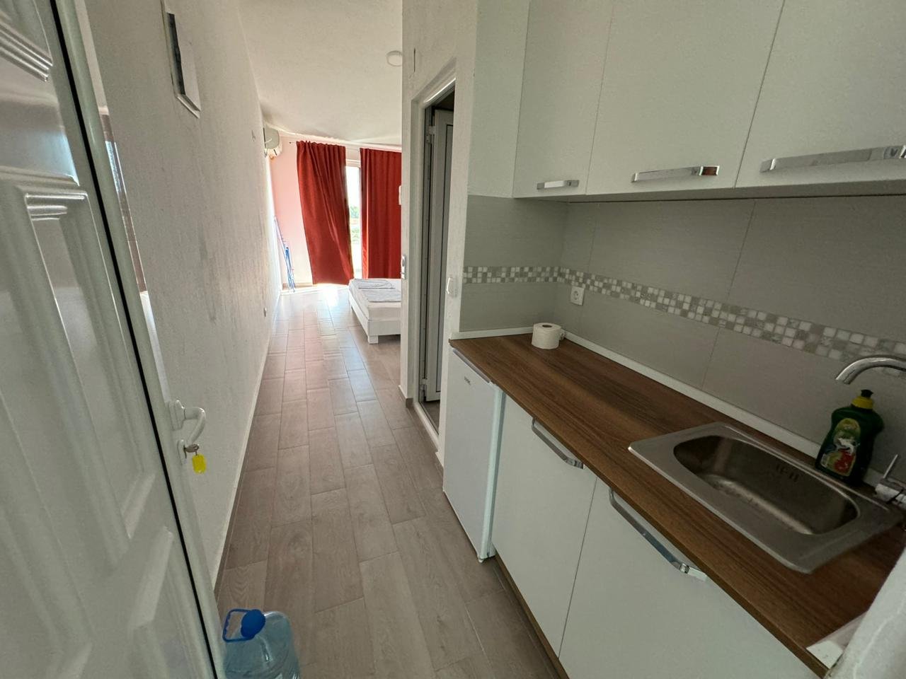 Modern Ulcinj apartment for sale: sleek kitchenette, cozy layout, bed by balcony. Top property on immorenta.me by Ekosphere DOO.