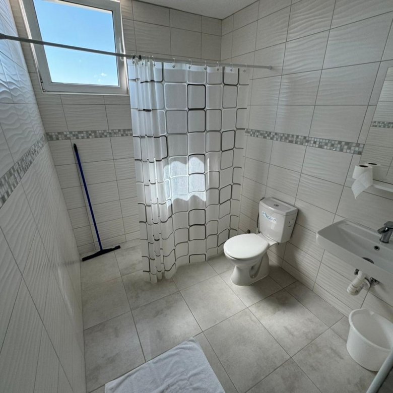 Modern tiled bathroom in Ulcinj property: shower, window, sink. Great investment on immorenta.me by ekosphere doo.