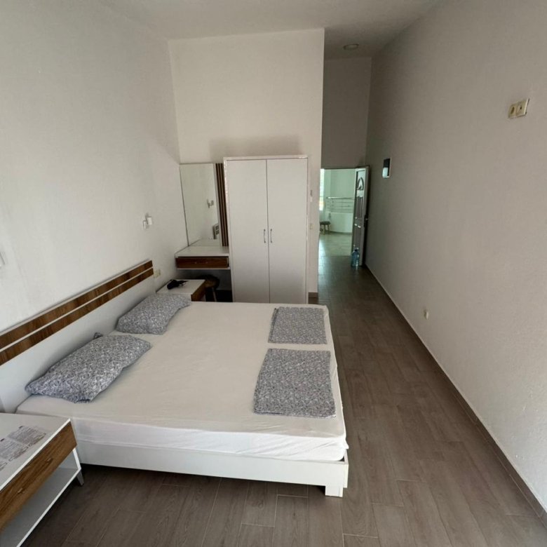 Stylish minimalist bedroom in Ulcinj, Montenegro real estate; double bed, storage, sleek design. Invest with immorenta.me by ekosphere doo.