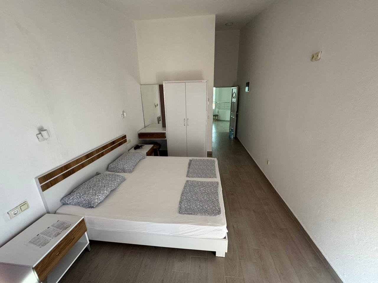 Stylish minimalist bedroom in Ulcinj, Montenegro real estate; double bed, storage, sleek design. Invest with immorenta.me by ekosphere doo.