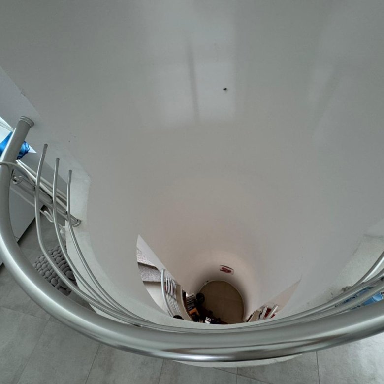 Elegant spiral staircase with metal railings and white walls, ideal Ulcinj property; ekosphere window highlights investment appeal.