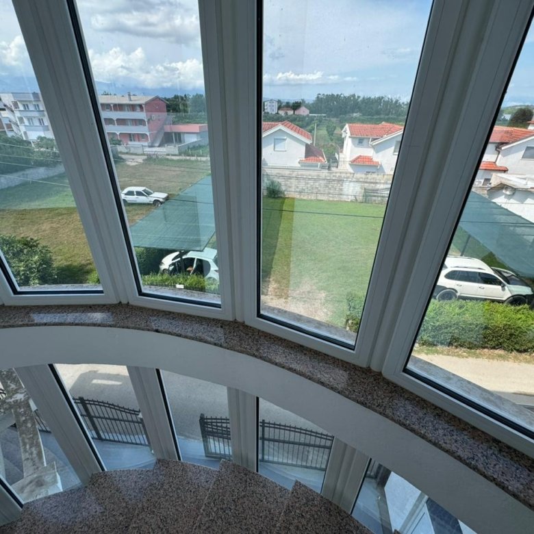 Stunning Ulcinj property view: elegant curved staircase, panoramic windows, lush lawns, red-roofed homes&mdash;exclusive on immorenta.me, a project of ekosphere doo.