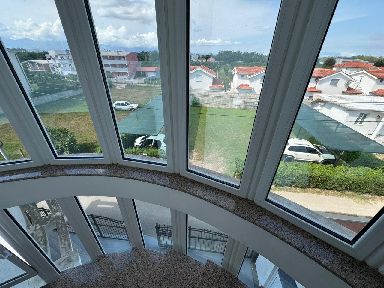 Stunning Ulcinj property view: elegant curved staircase, panoramic windows, lush lawns, red-roofed homes&acirc;exclusive on immorenta.me, a project of ekosphere doo.
