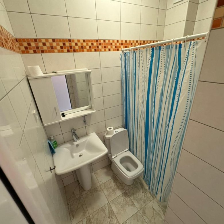 Modern small bathroom in Ulcinj with white tiles, pedestal sink, shower, ideal for property investment from Montenegro-Listings.me/Ekosphere doo.