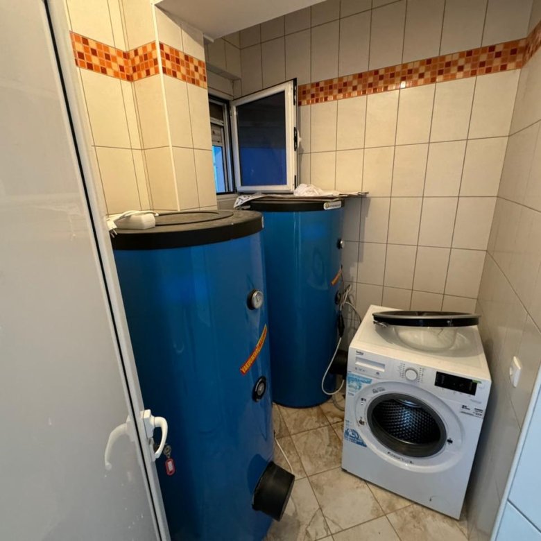 Modern, tiled utility room in Ulcinj with blue water tanks, laundry appliances&mdash;investment-ready property via immorenta.me by ekosphere doo.