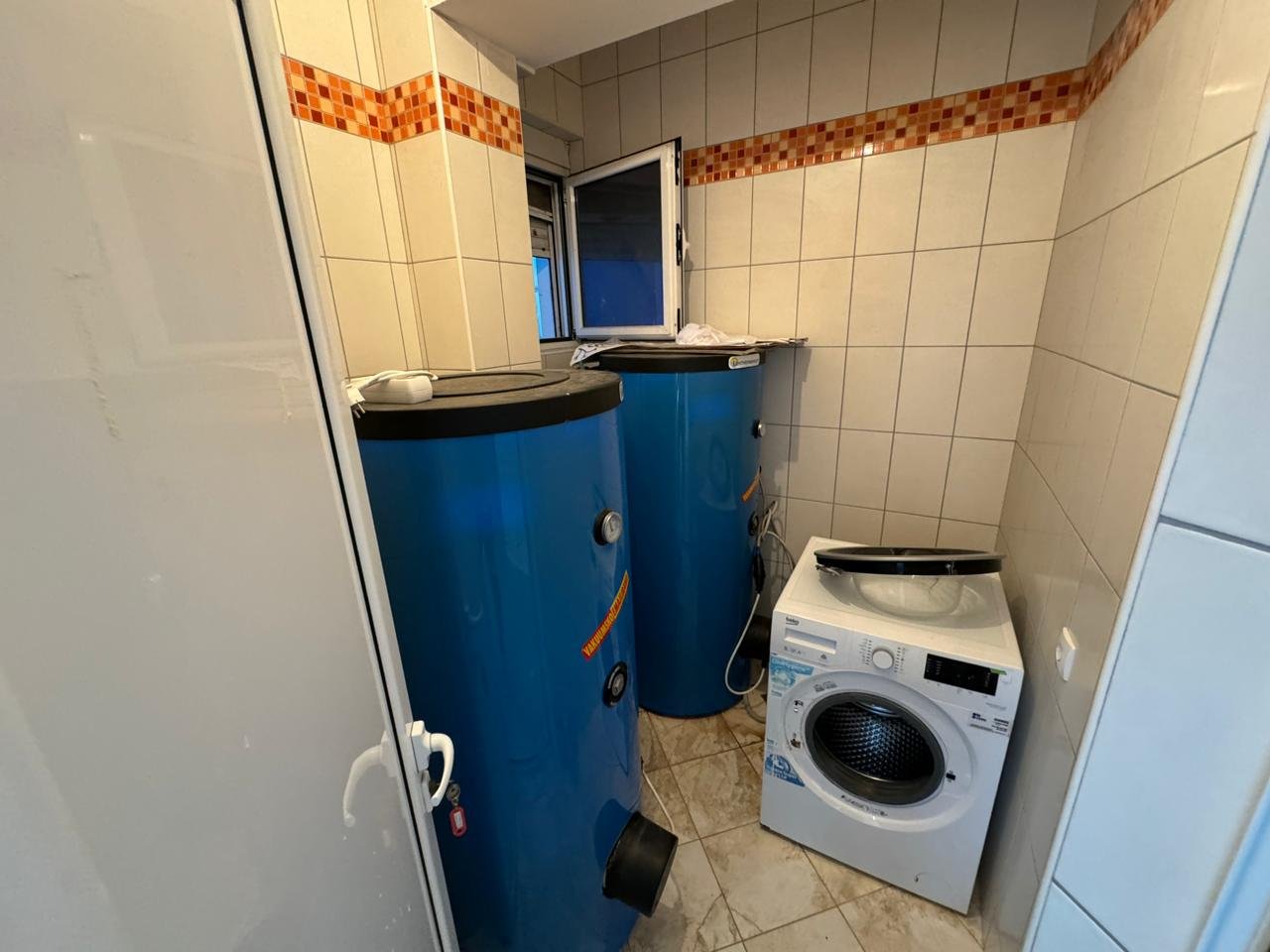 Modern, tiled utility room in Ulcinj with blue water tanks, laundry appliances&acirc;investment-ready property via immorenta.me by ekosphere doo.