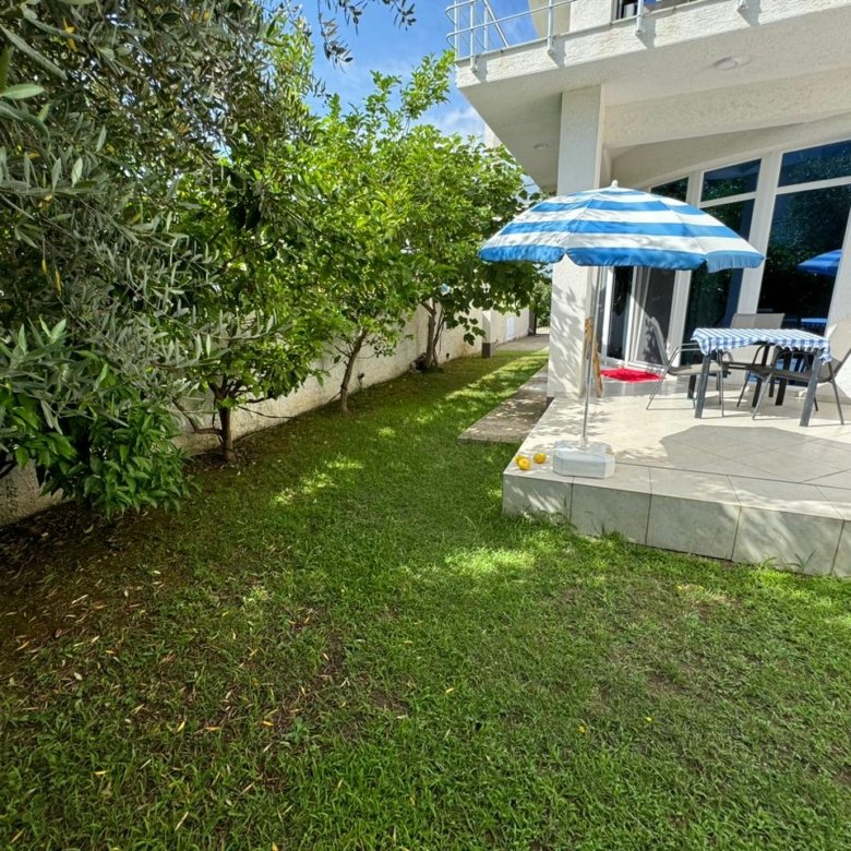 Charming Ulcinj home: lush backyard, patio, trees, and white house. Prime real estate by ekosphere doo on immorenta.me.