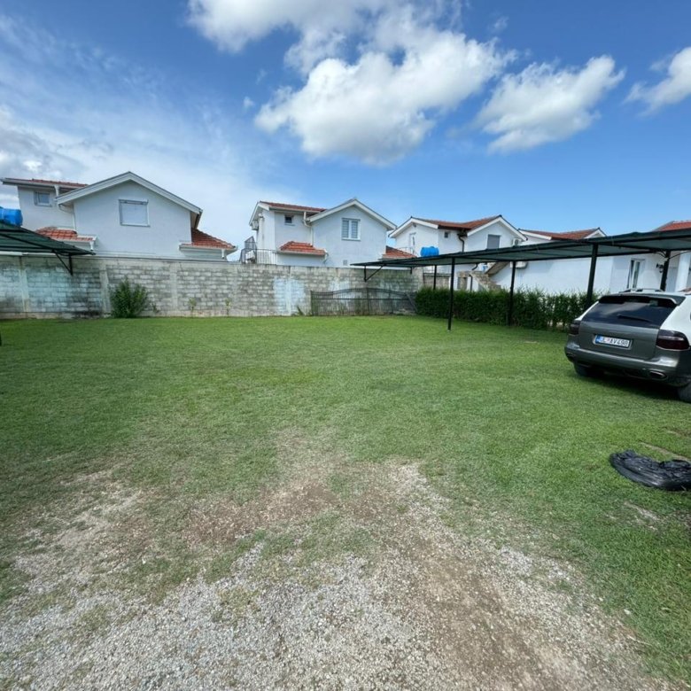 Prime Ulcinj real estate: modern homes with white walls, red roofs, carports, and green parking. Exclusive on immorenta.me by ekosphere doo.