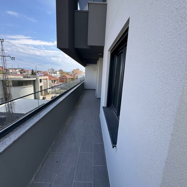 Modern balcony with glass railing and gray tiles, prime Ulcinj real estate; great views&mdash;exclusive on immorenta.me by ekosphere doo.