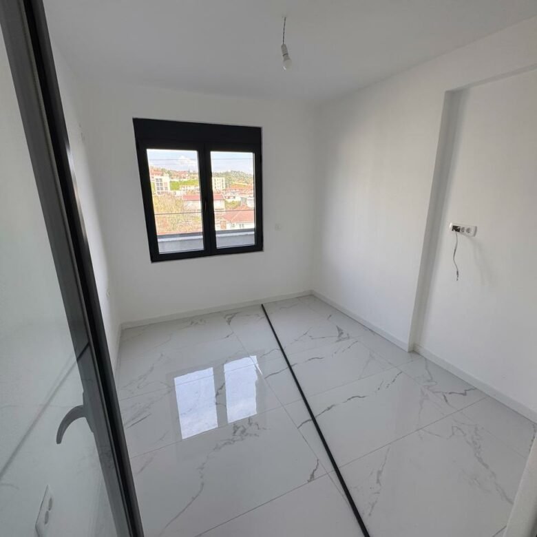 Modern, light-filled Ulcinj property: pristine white walls, glossy tiled floors, large window&mdash;prime investment via ekosphere doo.