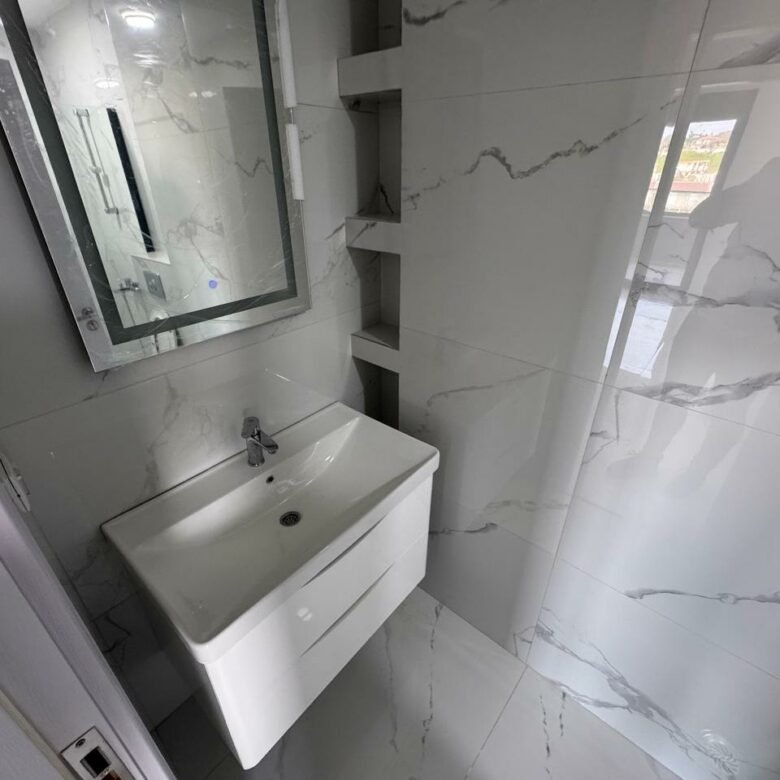 Luxury bathroom in Ulcinj: white marble, modern sink, built-ins, bright space. Invest with immorenta.me by Ekosphere D.O.O.