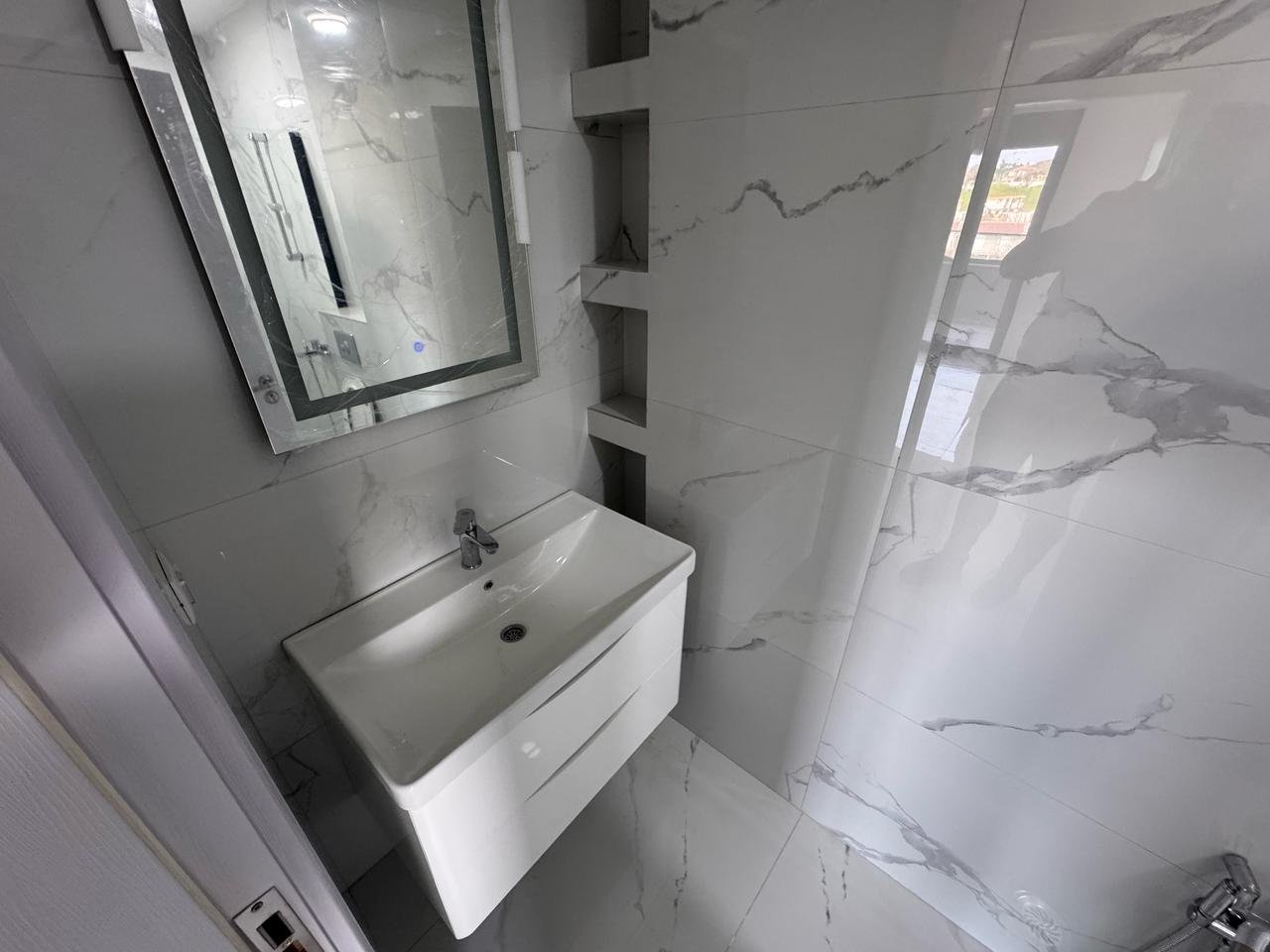 Luxury bathroom in Ulcinj: white marble, modern sink, built-ins, bright space. Invest with immorenta.me by Ekosphere D.O.O.
