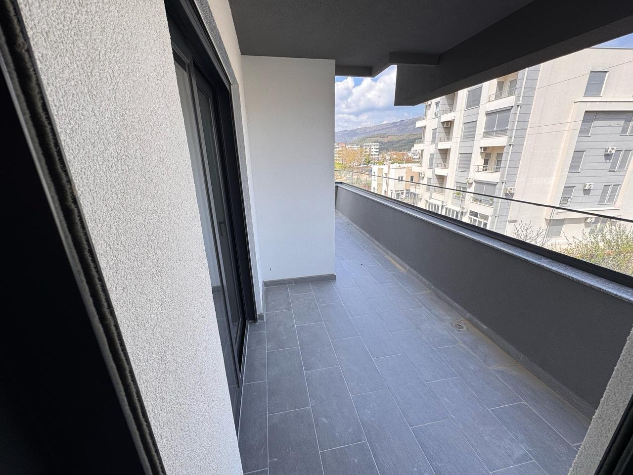 Stylish Ulcinj balcony with gray tiles, glass door, private wall; invest in Montenegro real estate via immorenta.me by ekosphere doo.