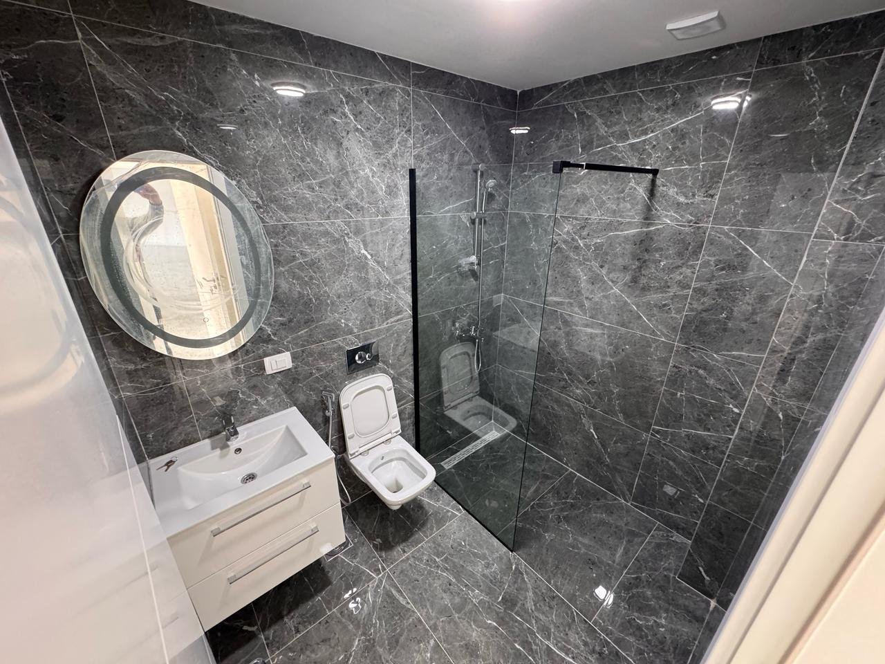 Luxurious Ulcinj property: elegant bathroom with marble, walk-in shower, and chic vanity&mdash;immorenta.me by Ekosphere DOO.
