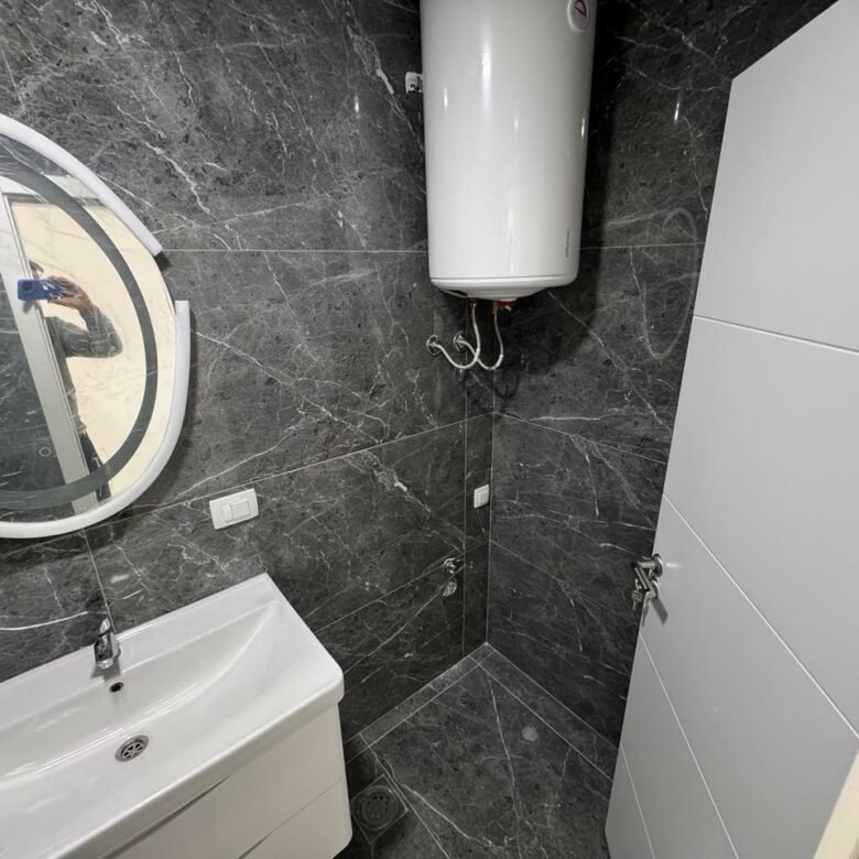 Modern bathroom in Ulcinj property with luxe dark marble, wall-mounted sink, quality fittings; exclusive via immorenta.me/Ekosphere.