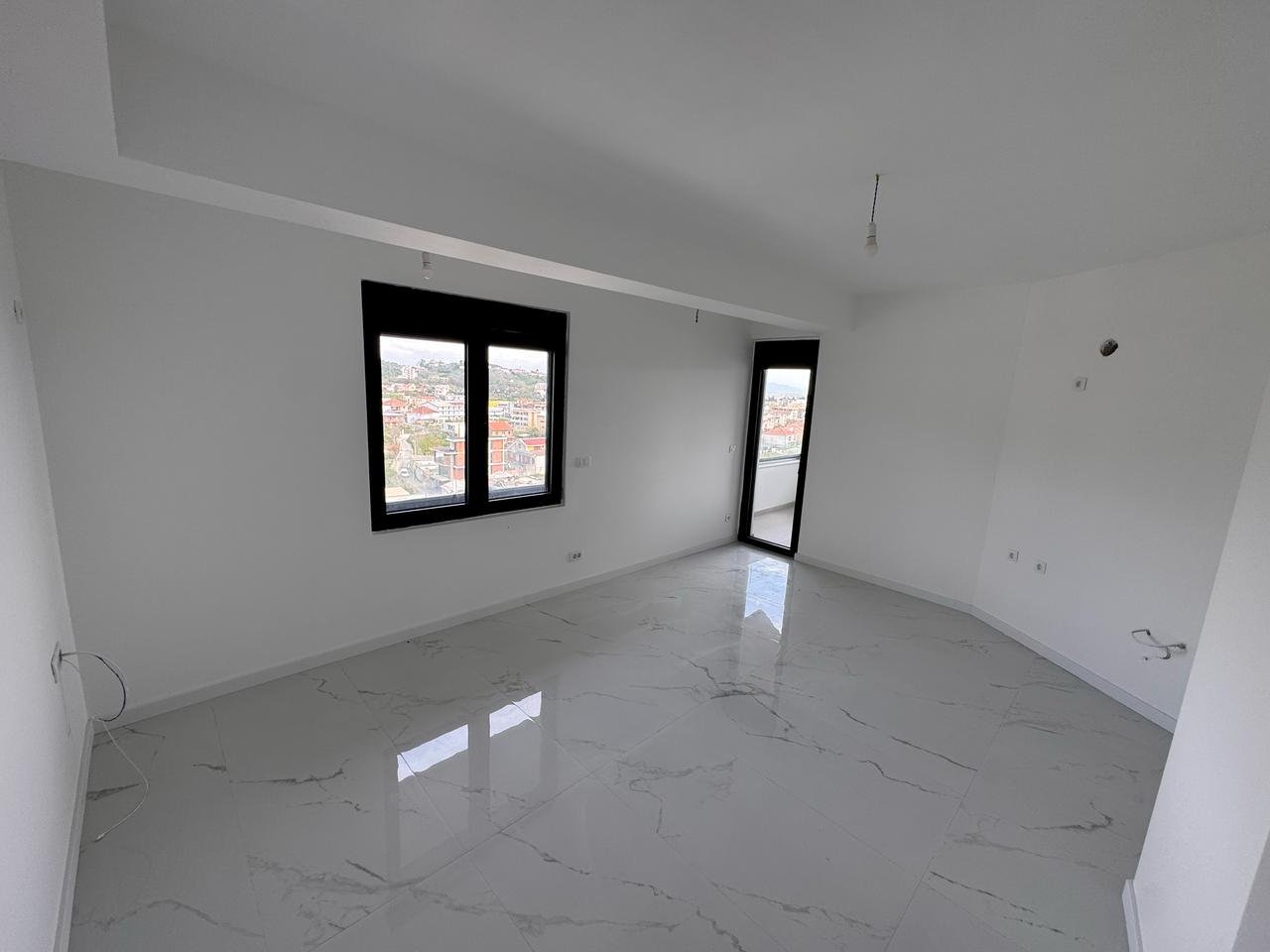 Modern Ulcinj property: bright room, marble tiles, stylish black windows. Prime investment by ekosphere doo at immorenta.me.