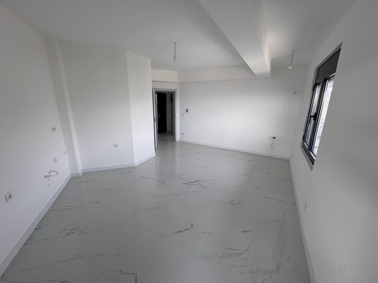 Bright, spacious room with white walls and marble tiles&mdash;prime Ulcinj real estate by ekosphere doo. Ideal property investment.