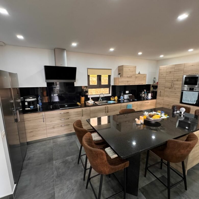 Stylish Ulcinj kitchen: wood cabinets, black appliances, spacious island&mdash;exclusive on immorenta.me by Ekosphere doo.