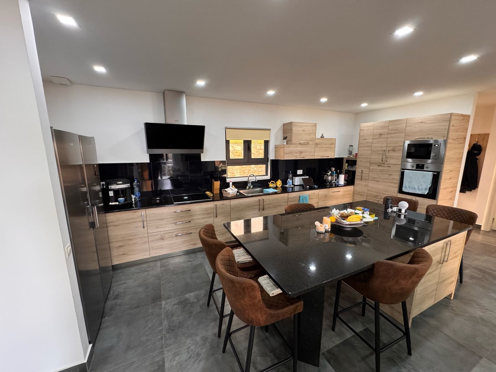 Stylish Ulcinj kitchen: wood cabinets, black appliances, spacious island&mdash;exclusive on immorenta.me by Ekosphere doo.