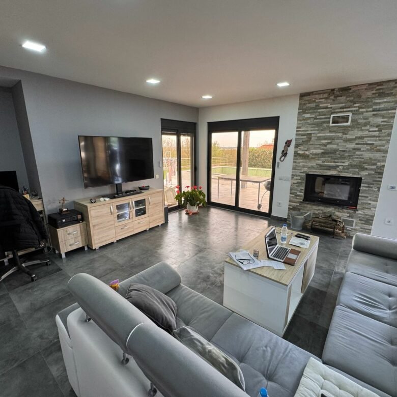 Stunning Ulcinj living room with gray sectional, fireplace, large windows&mdash;prime property for sale on immorenta.me by Ekosphere.