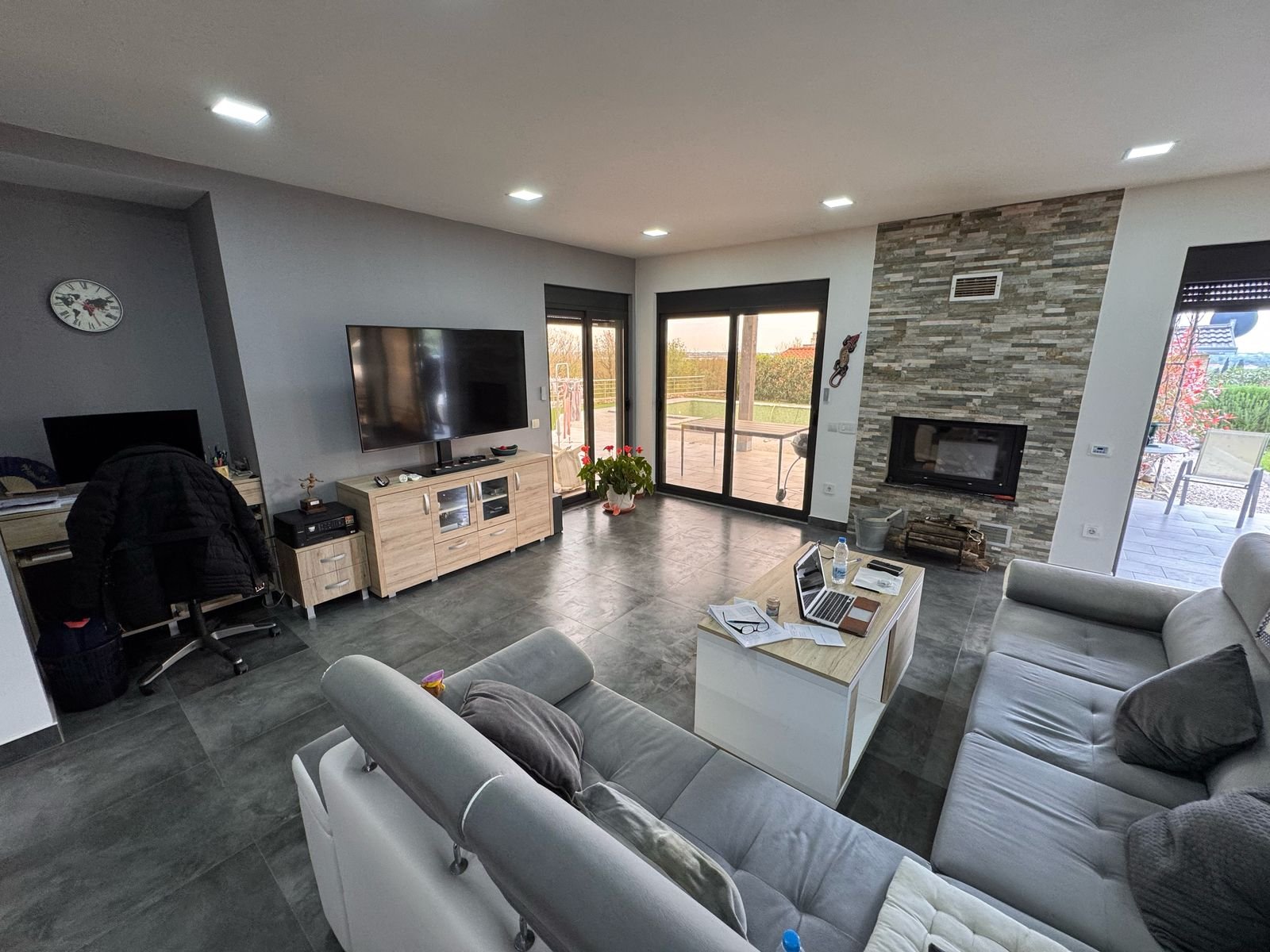 Stunning Ulcinj living room with gray sectional, fireplace, large windows&mdash;prime property for sale on immorenta.me by Ekosphere.