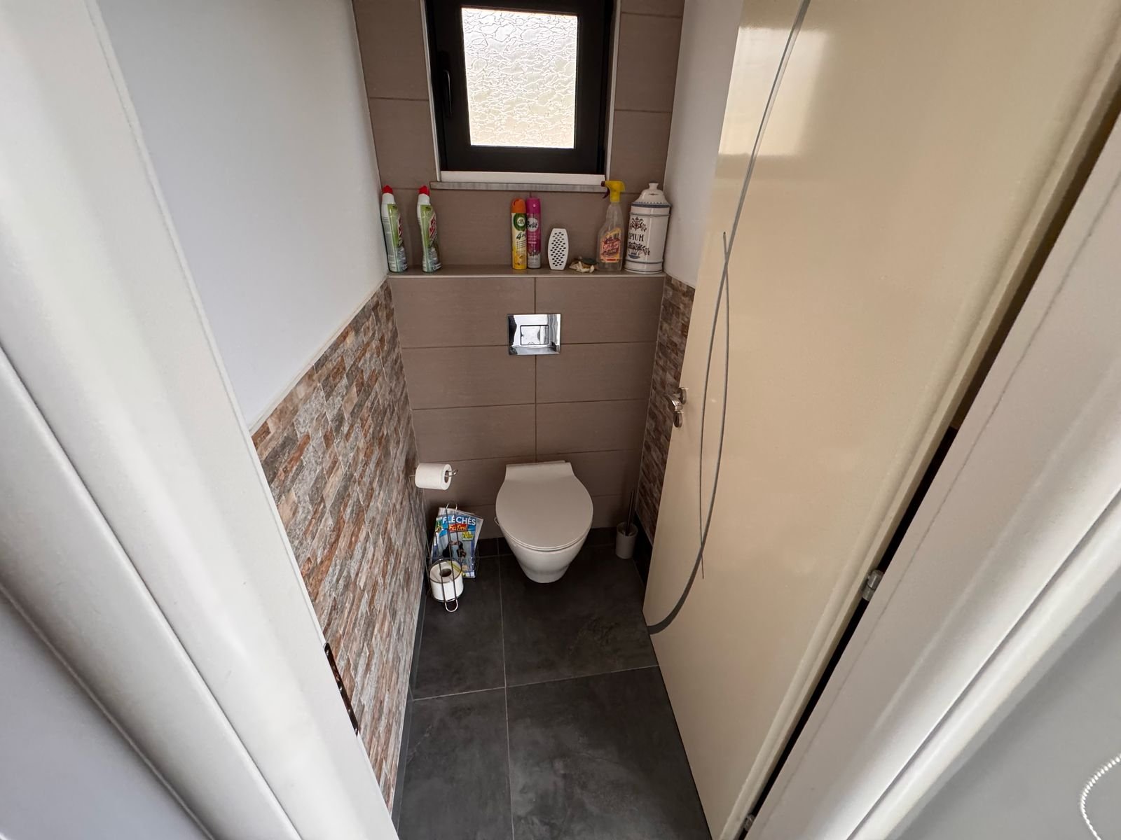 Modern bathroom in Ulcinj property: wall-mounted toilet, bidet, brick/tile accents. Invest with immorenta.me by ekosphere doo.