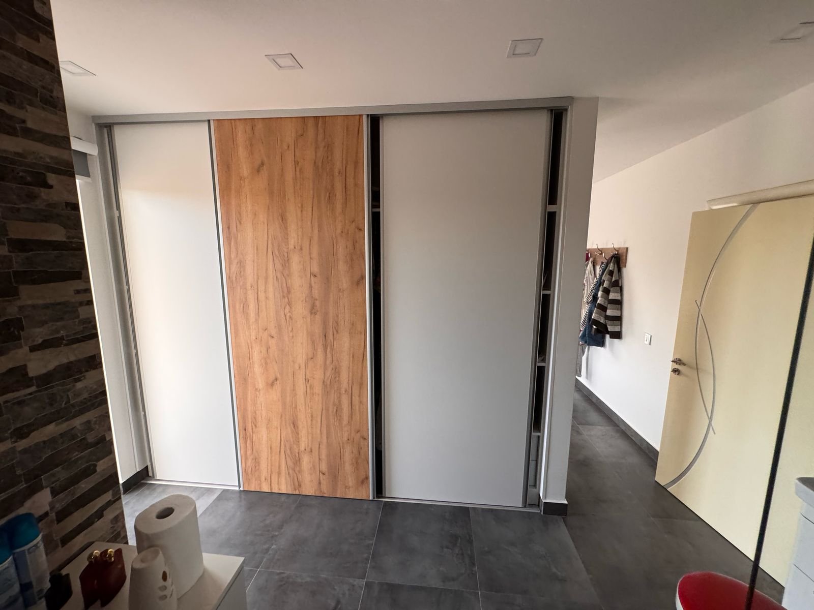 Invest in Ulcinj: Modern room with gray tiles, stone wall, sleek wardrobe, yellow door. Exclusive by Ekosphere DOO at immorenta.me.