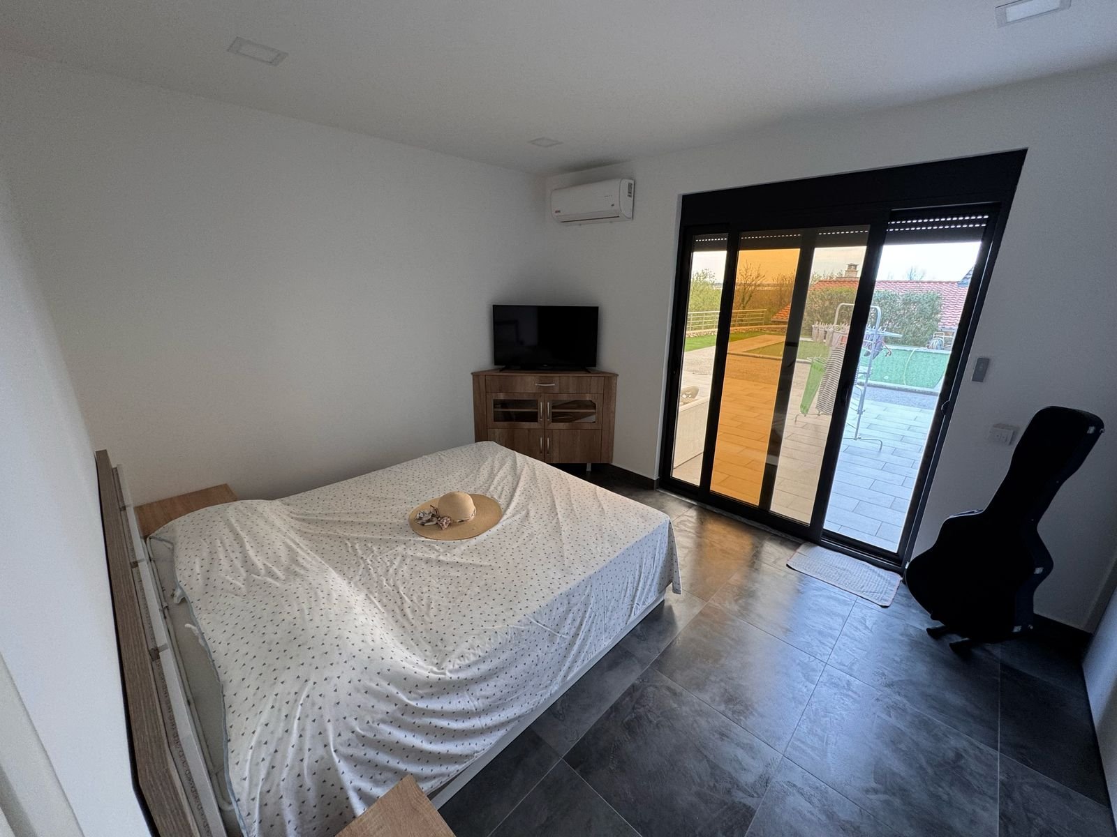 Stylish Ulcinj bedroom: double bed, modern decor, TV cabinet, patio access with lush views&mdash;Investment gem on immorenta.me by ekosphere doo.