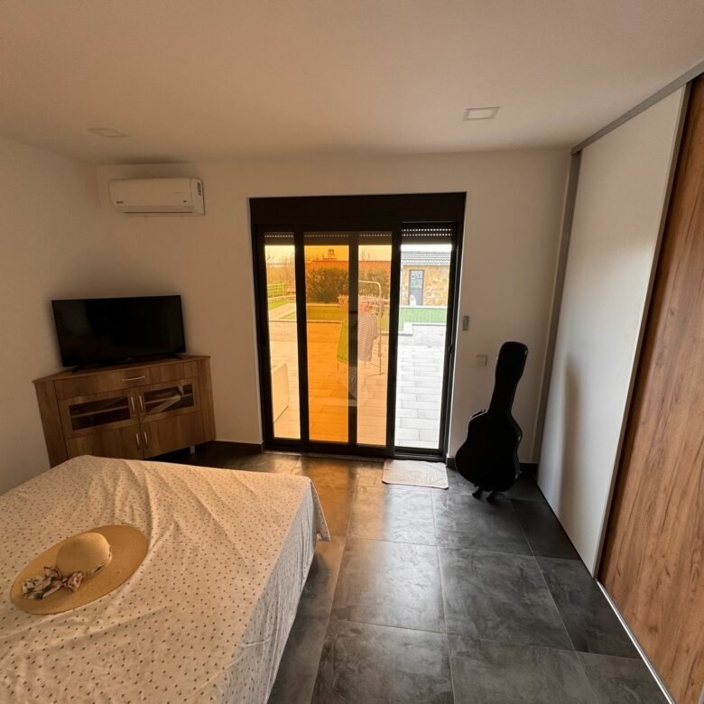 Elegant Ulcinj bedroom with patio access, stylish furnishings, and sustainable design&mdash;exclusive Ekosphere offer at immorenta.me.